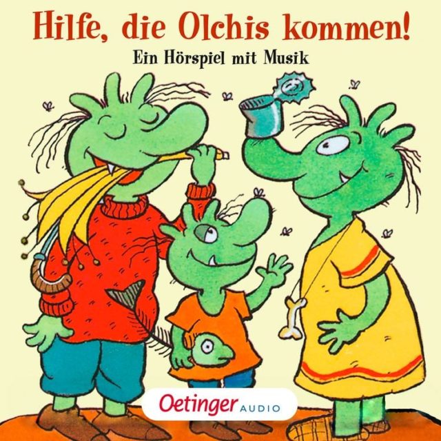 Drei grüne Olchi-Figuren mit spitzen Ohren und Zähnen, eine trägt roten Pullover und blaue Hose, eine orange T-Shirt mit Fisch, eine gelbes Kleid mit Knochenkette.